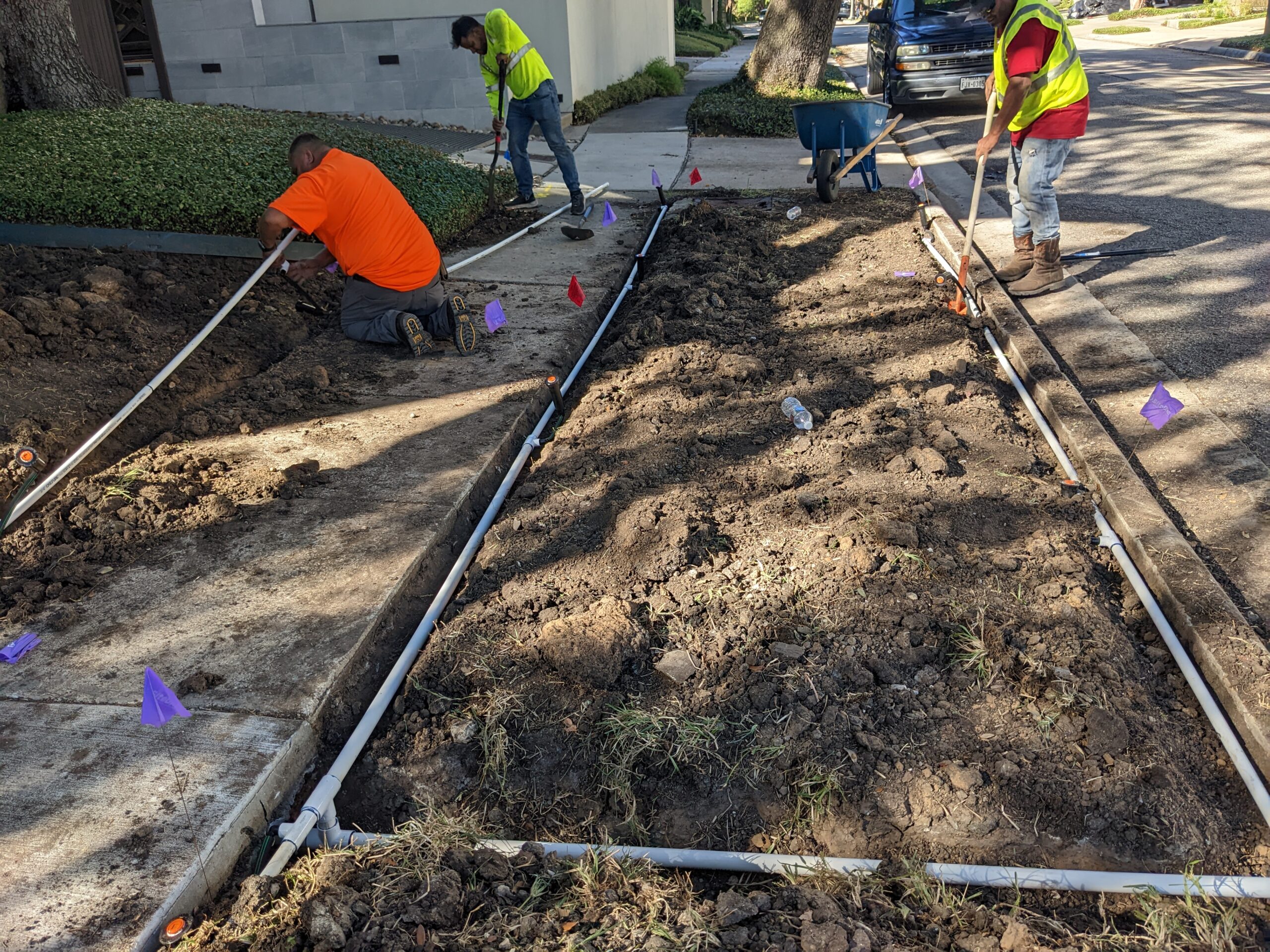 Workers digging up ground for sprinkler installation